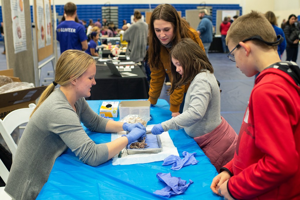 A 51СƳstudent works with kids during the CEN Brain Fair event